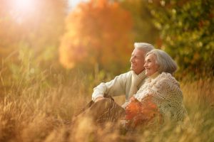 Senior couple sitting in grass looking straight ahead